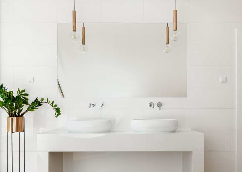 gold light fixtures and glossy white bathroom